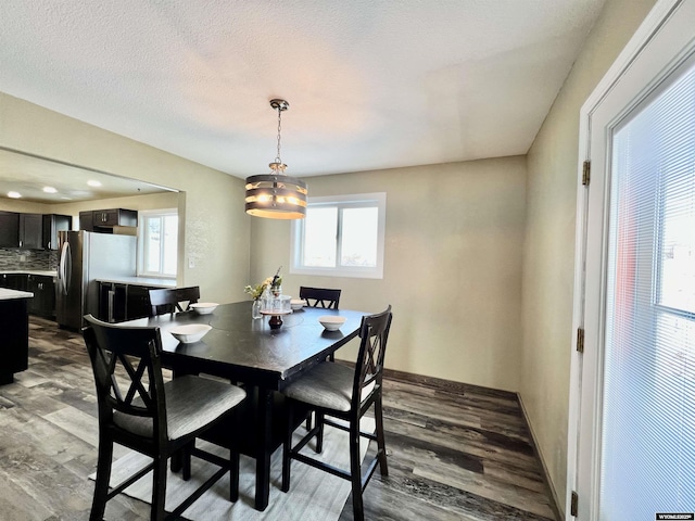 dining area with wood-type flooring and a textured ceiling