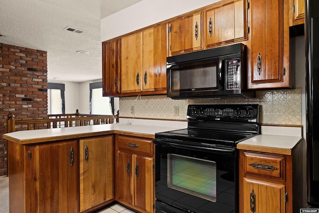 kitchen featuring brick wall, tasteful backsplash, black appliances, kitchen peninsula, and a textured ceiling