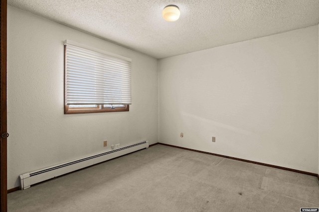 carpeted spare room with a baseboard radiator and a textured ceiling