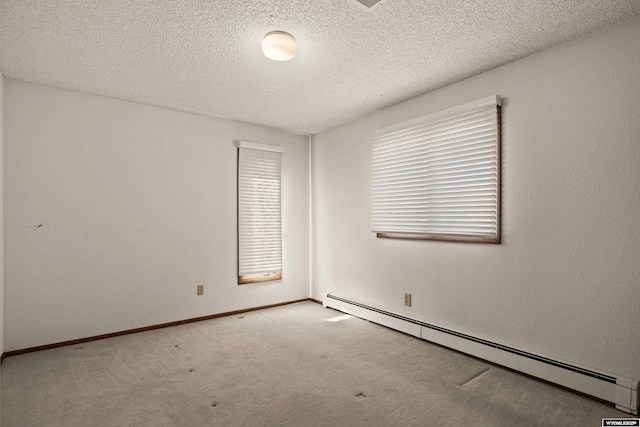 carpeted empty room with baseboard heating and a textured ceiling