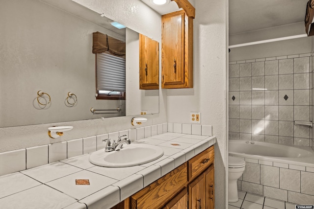 full bathroom featuring vanity, tiled shower / bath, tile patterned flooring, and toilet