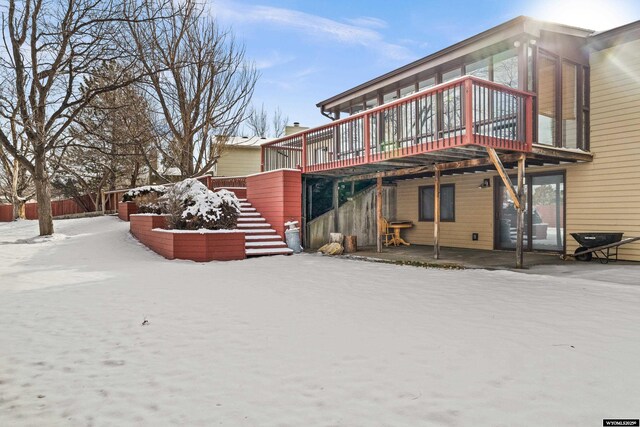 snow covered property with a deck