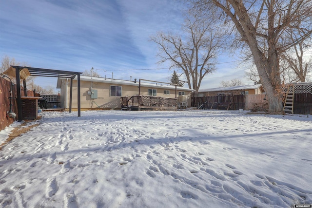 snow covered rear of property with a wooden deck