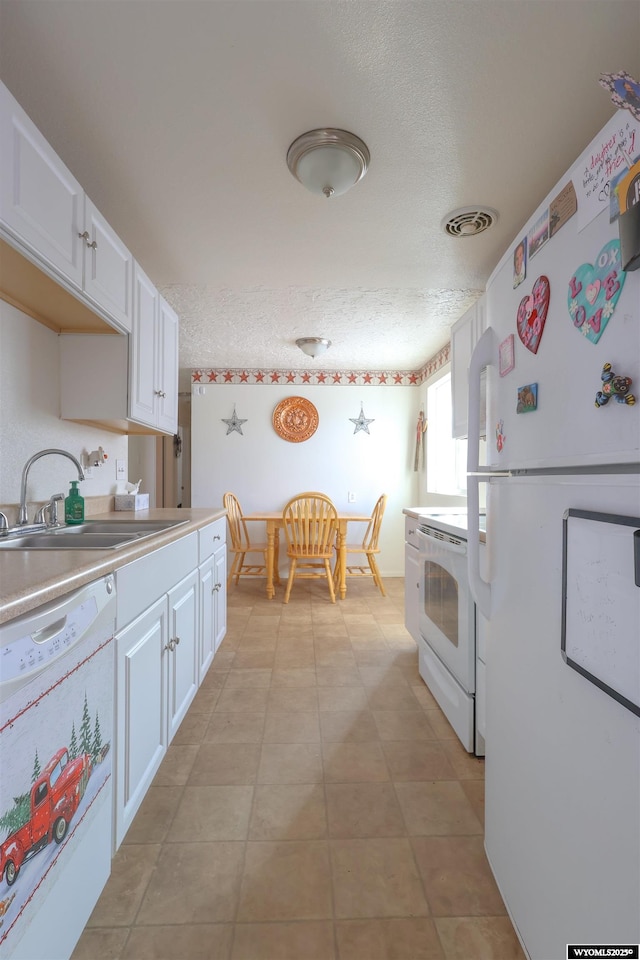 kitchen featuring a textured ceiling, sink, white cabinets, and white appliances