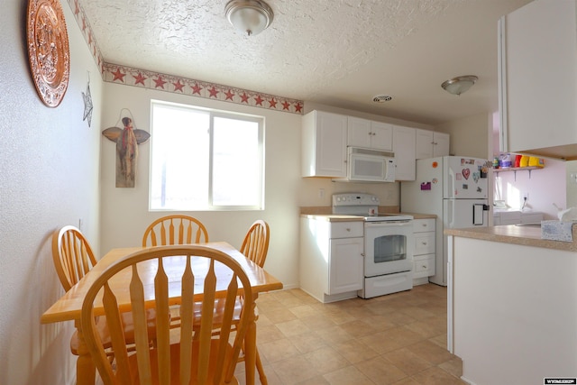 kitchen featuring white cabinetry, white appliances, and a textured ceiling