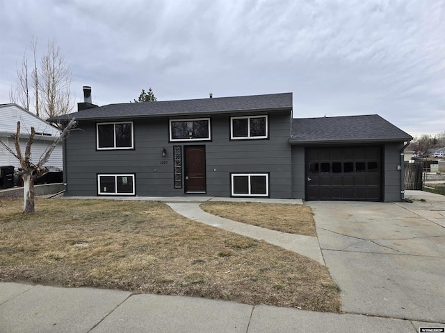 raised ranch with a front yard and a garage