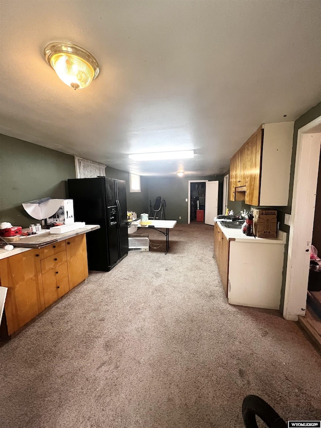 kitchen with light carpet and black refrigerator with ice dispenser