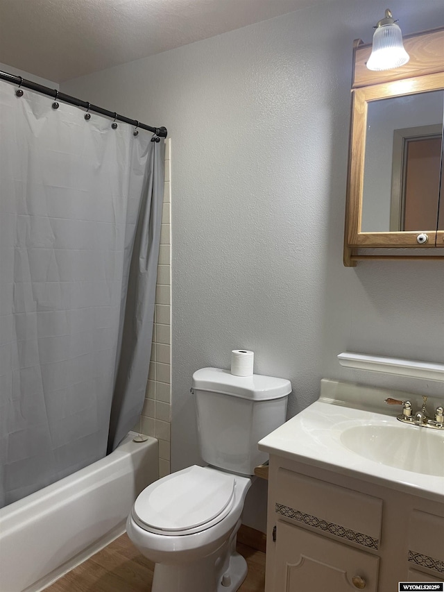 full bathroom featuring a textured ceiling, vanity, toilet, and shower / bath combo with shower curtain