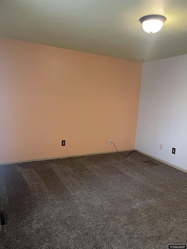 carpeted spare room featuring a textured ceiling