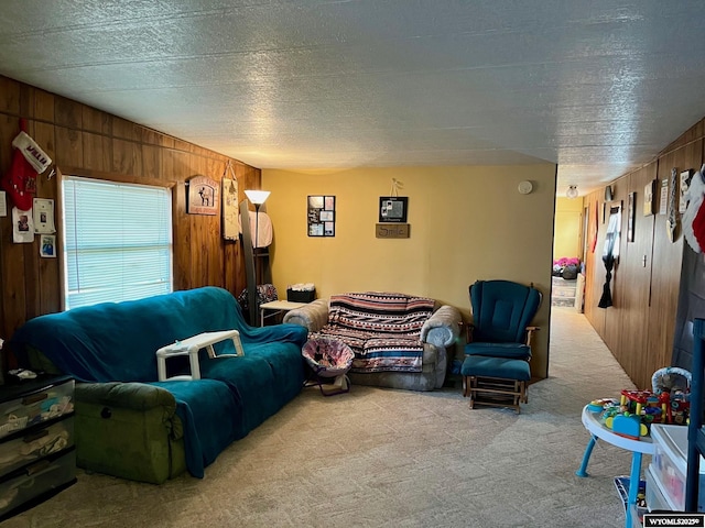 living room featuring wooden walls, light carpet, and a textured ceiling