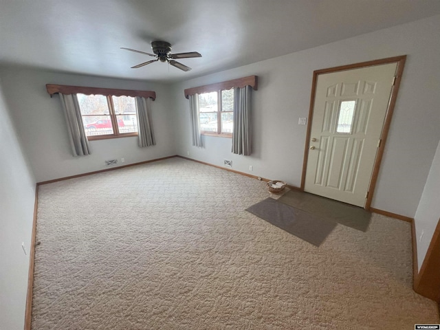 foyer entrance with carpet flooring and ceiling fan