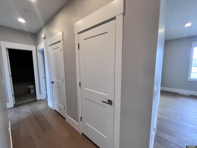 corridor with hardwood / wood-style flooring