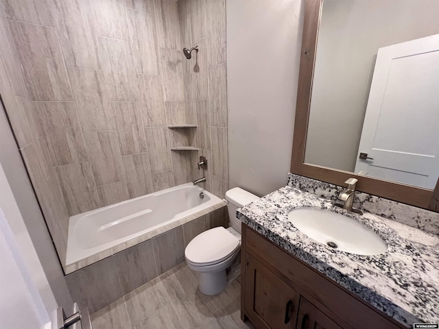 full bathroom featuring tiled shower / bath combo, toilet, and vanity