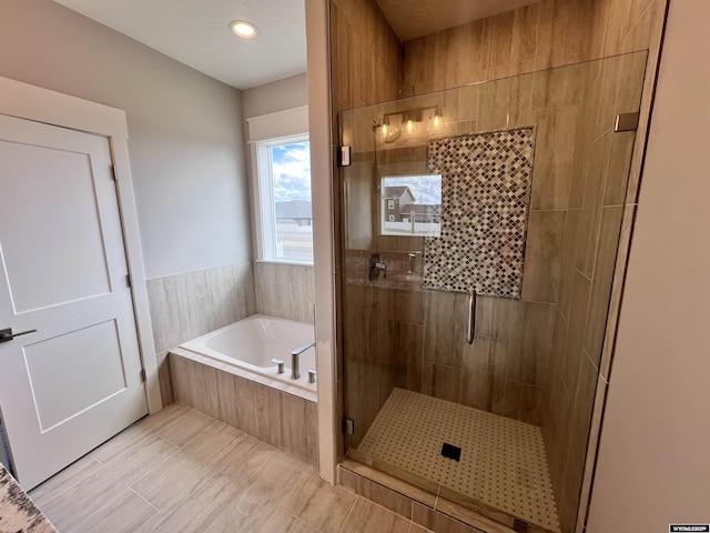 bathroom with separate shower and tub and tile patterned flooring