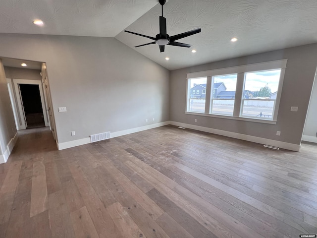 empty room featuring ceiling fan, light hardwood / wood-style floors, and vaulted ceiling