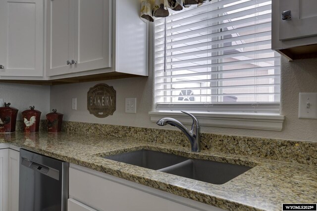 kitchen featuring dishwasher, a healthy amount of sunlight, white cabinetry, and sink