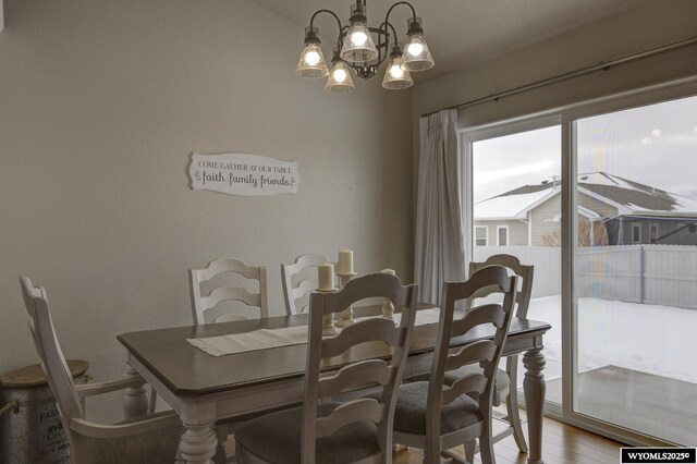 dining area with wood-type flooring and a chandelier