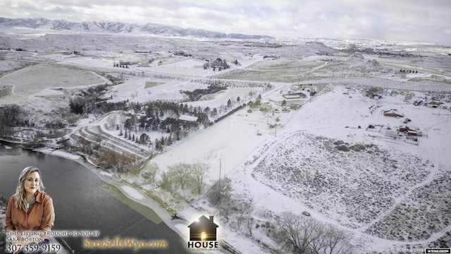 snowy aerial view with a water and mountain view