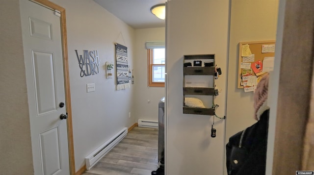 hall featuring light wood-type flooring and a baseboard heating unit