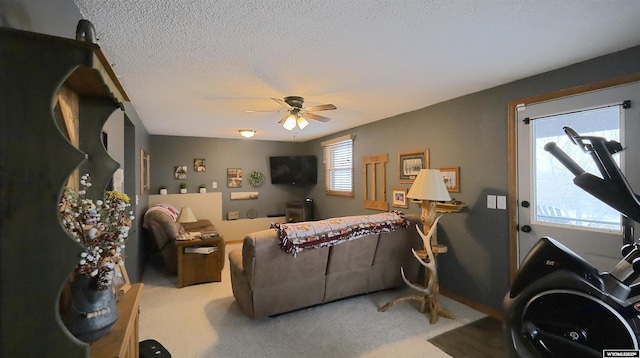 living room with a textured ceiling, carpet floors, and ceiling fan