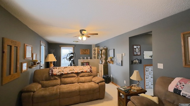 carpeted living room with ceiling fan and a textured ceiling