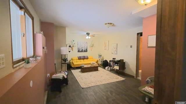 living room featuring ceiling fan and dark hardwood / wood-style floors