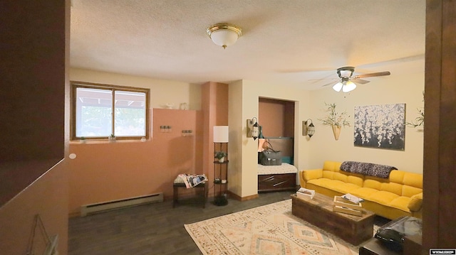 living room featuring a textured ceiling, ceiling fan, dark wood-type flooring, and a baseboard heating unit