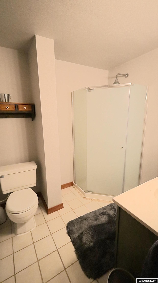 bathroom with tile patterned floors, vanity, toilet, and a shower