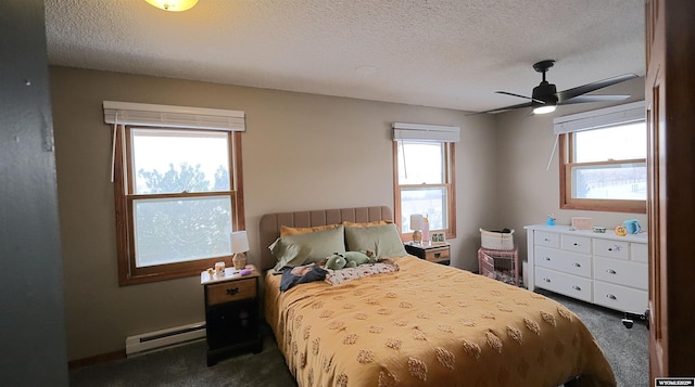 bedroom featuring dark colored carpet, a textured ceiling, ceiling fan, and a baseboard heating unit