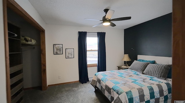 bedroom featuring a textured ceiling, dark carpet, and ceiling fan