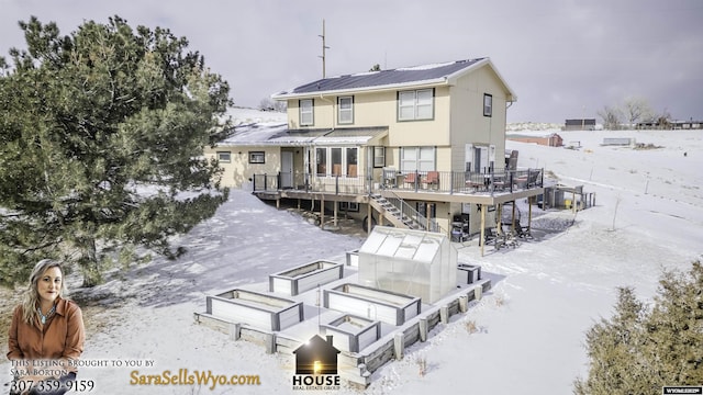 snow covered house with a wooden deck and an outdoor structure