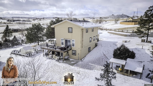 snow covered property featuring a deck