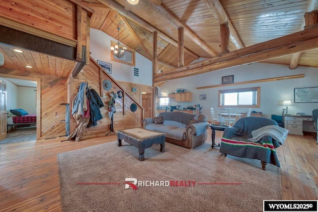 living room featuring beamed ceiling, wood walls, wooden ceiling, and high vaulted ceiling