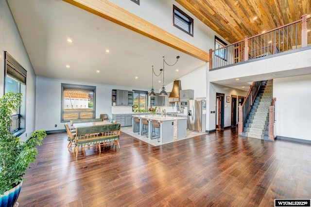 interior space featuring a towering ceiling and dark wood-type flooring