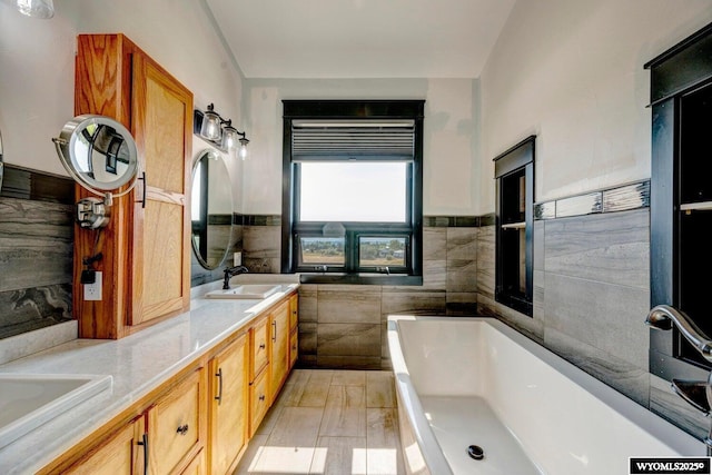 bathroom featuring a bathtub, tile walls, and vanity