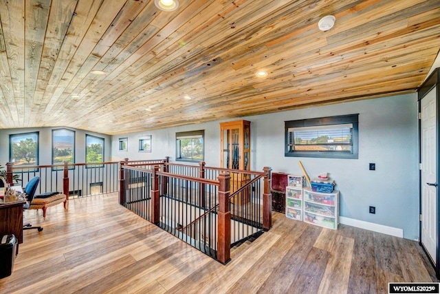 hall with wood-type flooring, lofted ceiling, and wooden ceiling