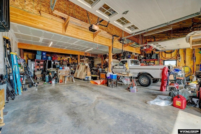 garage with a workshop area and a garage door opener