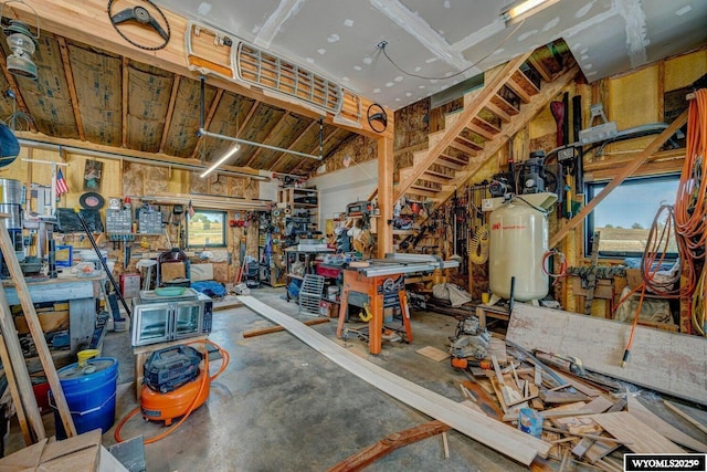 miscellaneous room featuring a workshop area, concrete flooring, and vaulted ceiling