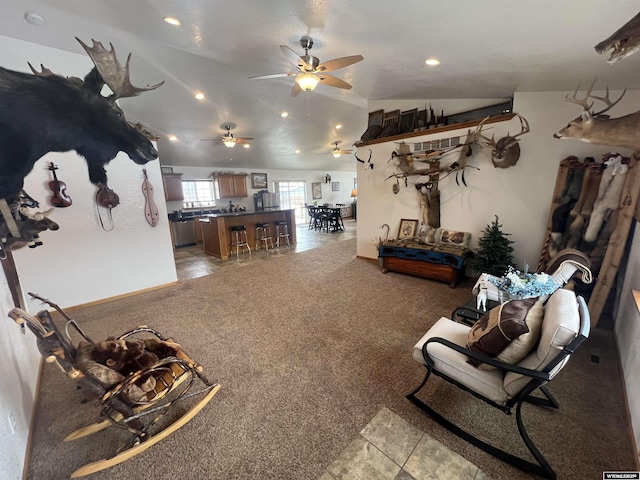 living room with ceiling fan, lofted ceiling, and light carpet