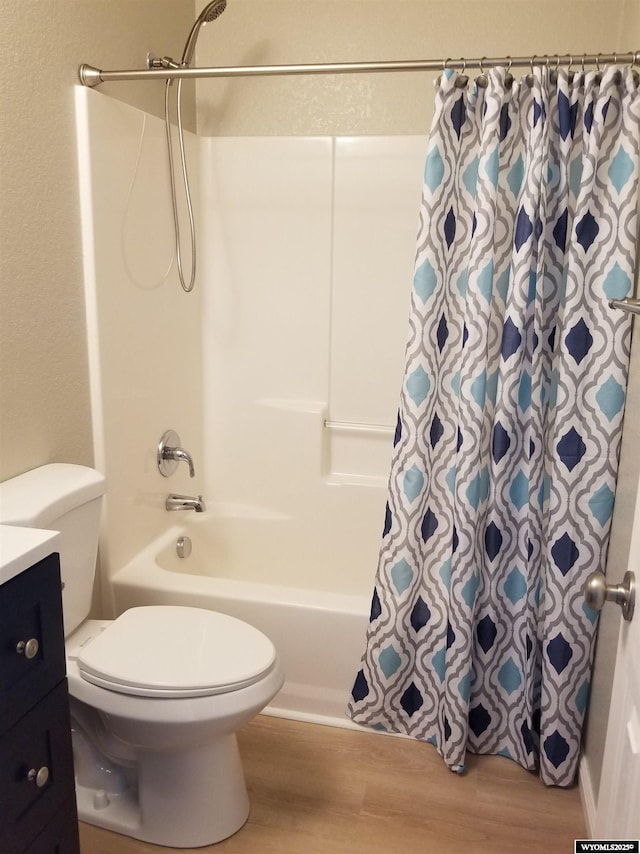 full bathroom featuring hardwood / wood-style flooring, vanity, toilet, and shower / bath combo with shower curtain