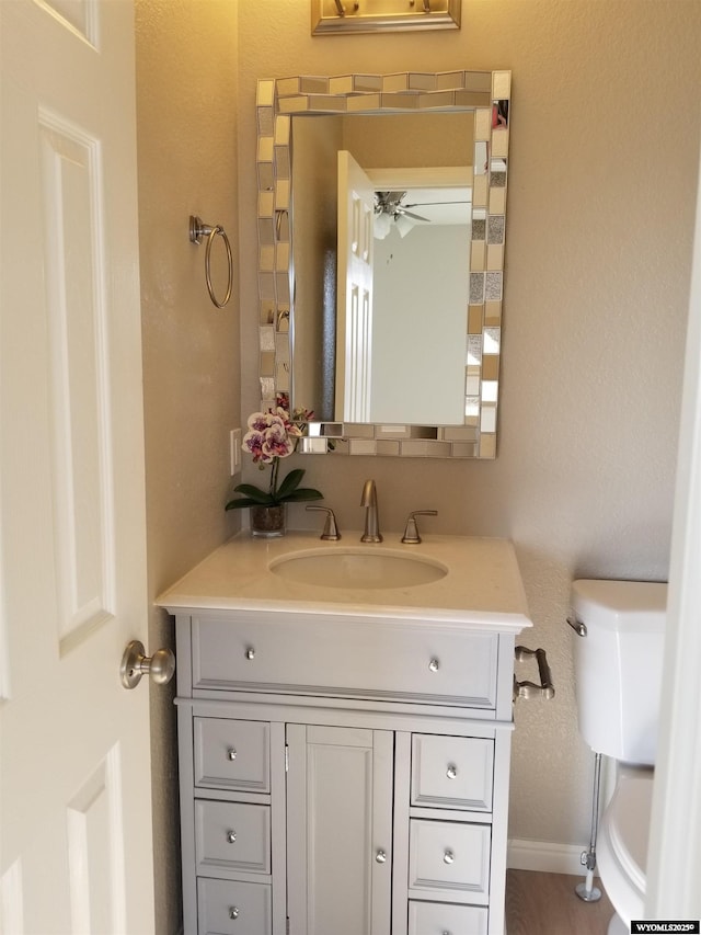 bathroom featuring vanity, ceiling fan, and toilet