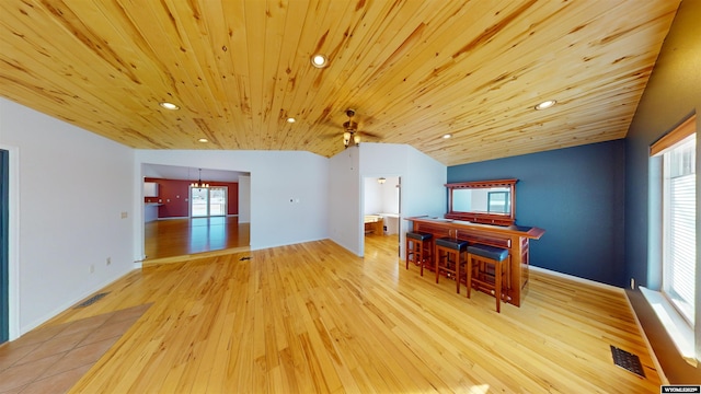 dining room with a healthy amount of sunlight, light hardwood / wood-style flooring, wooden ceiling, and lofted ceiling