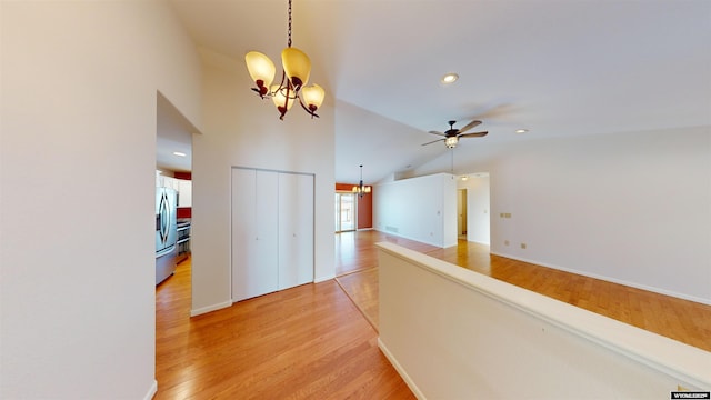 corridor featuring light hardwood / wood-style floors, high vaulted ceiling, and a notable chandelier