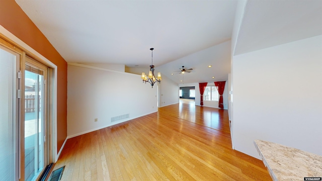 unfurnished dining area with light hardwood / wood-style flooring, ceiling fan with notable chandelier, and lofted ceiling