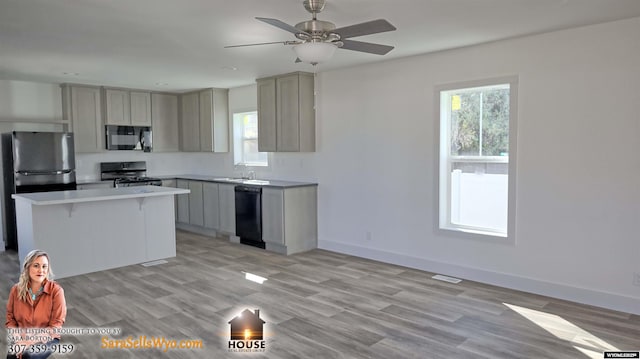 kitchen featuring black appliances, ceiling fan, gray cabinetry, and a kitchen bar