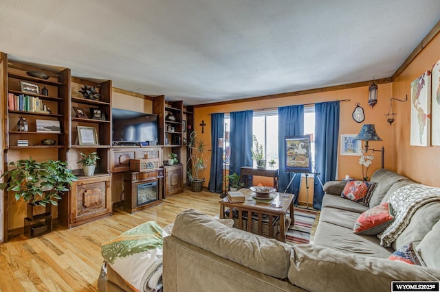 living room with crown molding, a textured ceiling, and light wood-type flooring