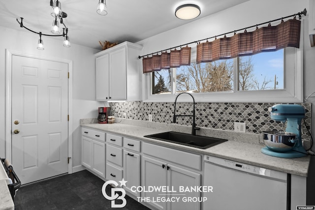 kitchen with white dishwasher, backsplash, white cabinetry, and sink