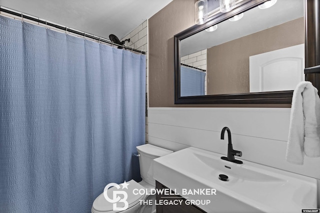 bathroom featuring vanity, curtained shower, and toilet