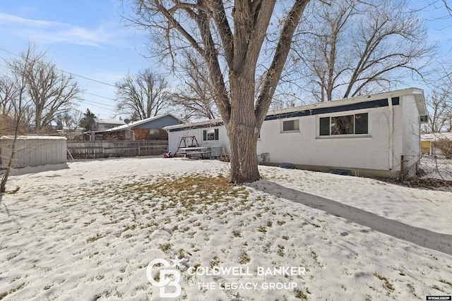 view of snow covered back of property