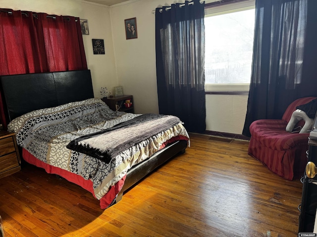 bedroom with wood-type flooring and crown molding